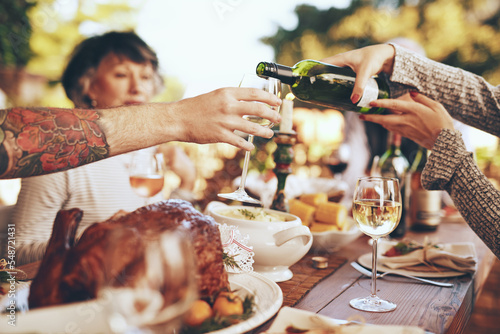 Photography Dinner, party and celebrate with hands and wine, wine glass to pour for drink, people with food outdoor, holiday or anniversary celebration