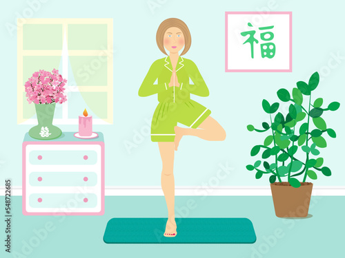girl is doing yoga in a green clothes in a blue room with flowers and candle time to relax meditation