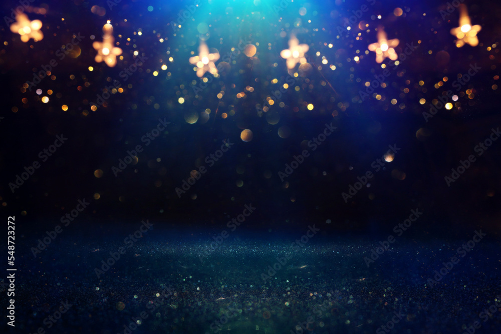 Fototapeta premium Christmas warm gold garland lights over dark background with glitter overlay