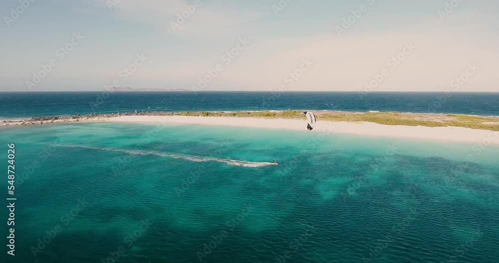 Man doing speed kiteboard along caribbean white sand beach, aerial view Los Roques Man doing speed kiteboard along caribbean white sand beach, aerial view Los Roques