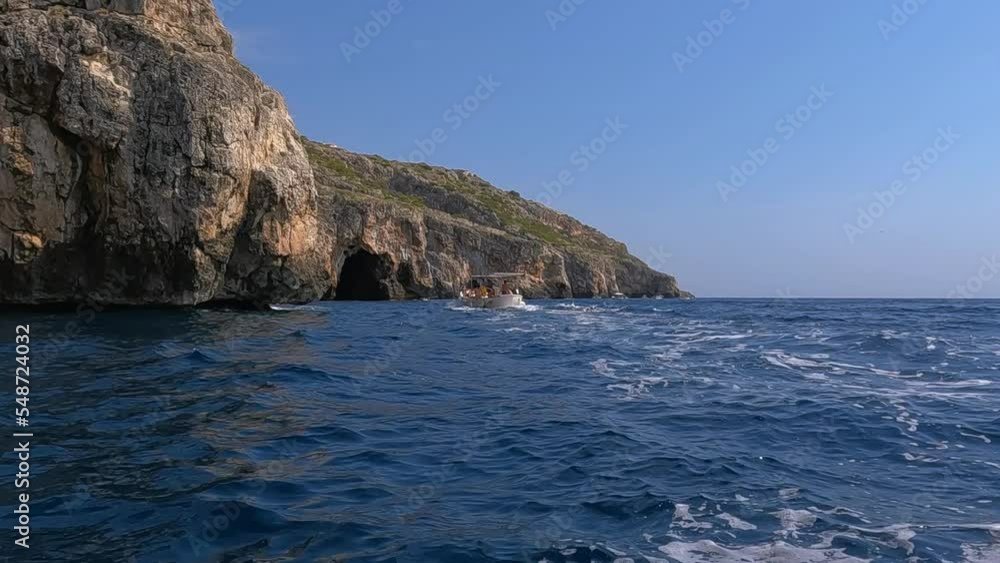 Motorboat navigates along Punta Meliso coastline where Ionian and Adriatic seas meet. Apulia region in Italy, slow motion Motorboat navigates along Punta Meliso coastline where Ionian and Adriatic seas meet. Apulia region in Italy, slow motion