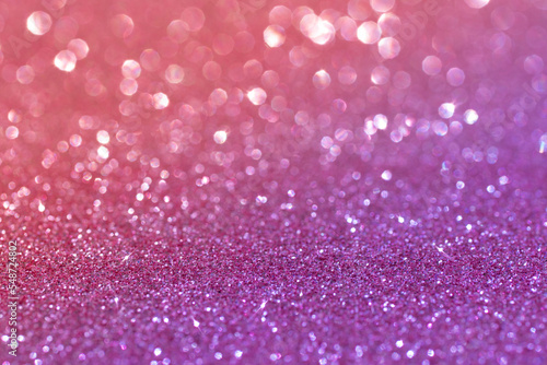 Bright sparkling glamorous background of purple and pink sequins. Abstract blurred shiny holiday background.