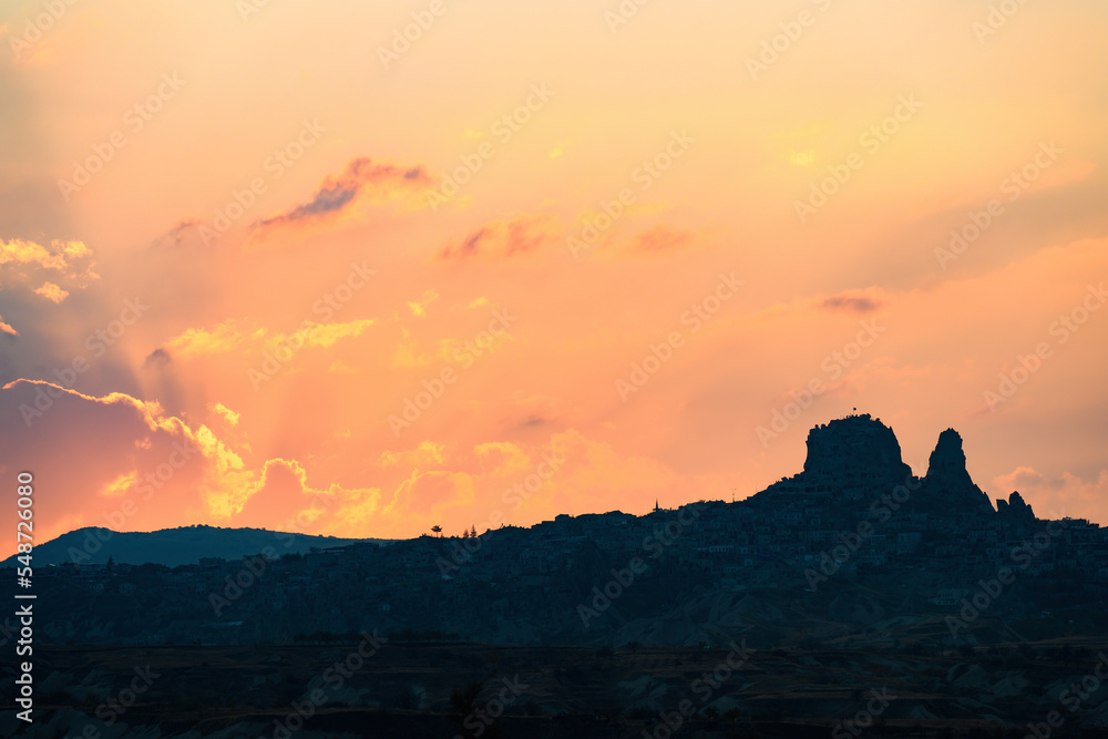 Stunning sunset behind the Uchisar Castle in Cappadocia. The Uchisar Castle is located in the town of Uchisar, and stands proudly as the highest point in Cappadocia. Goreme, central Antolia, Turkey.
