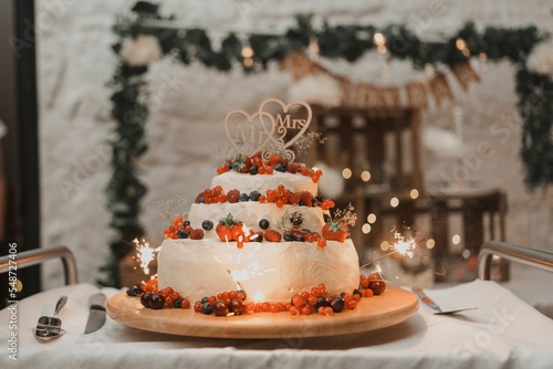 Closeup of a delicious wedding cake decorated with fresh berries isolated on a table