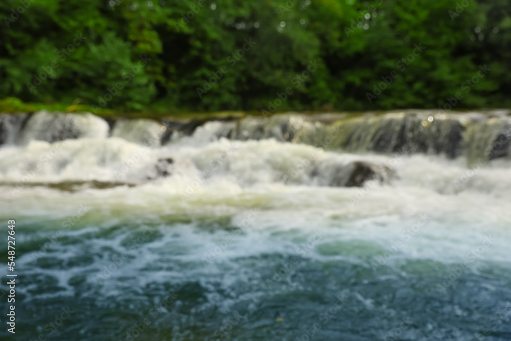 Blurred view of river with rapids near forest Blurred view of river with rapids near forest