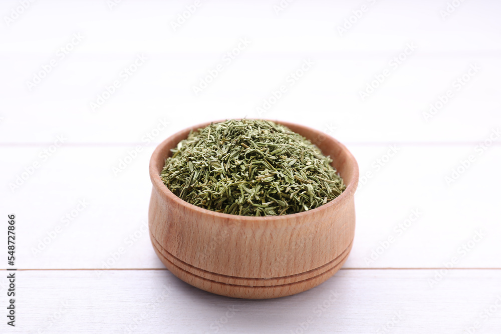 Bowl with dried thyme on white wooden table, closeup