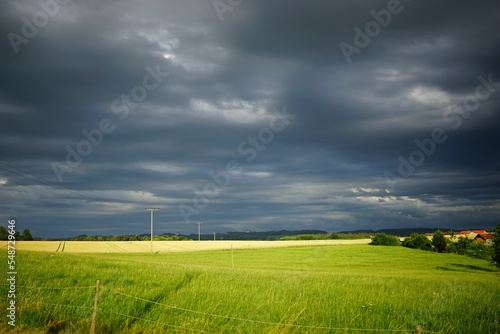 Beautiful greenfield view against dark storm clouds