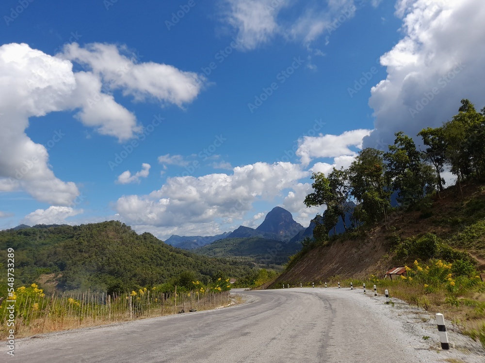 road in the mountains with beautiful blue sky and white clouds 