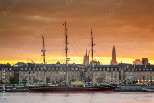 Tela Moored sailing ship with city buildings in the background