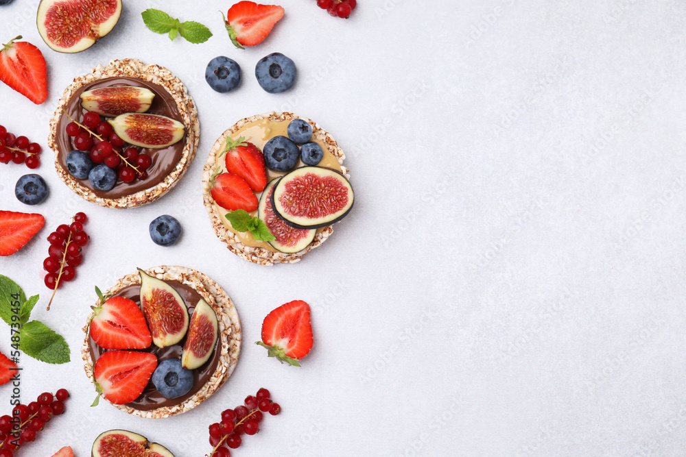 Flat lay composition with tasty crispbreads and berries on light table. Space for text
