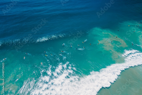 Fototapeta Naklejka Na Ścianę i Meble -  Surfers in ocean on surfboard and waves. Aerial view