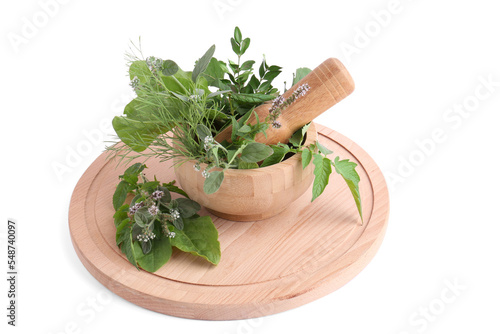 Wooden board and mortar with different herbs, flowers and pestle on white background