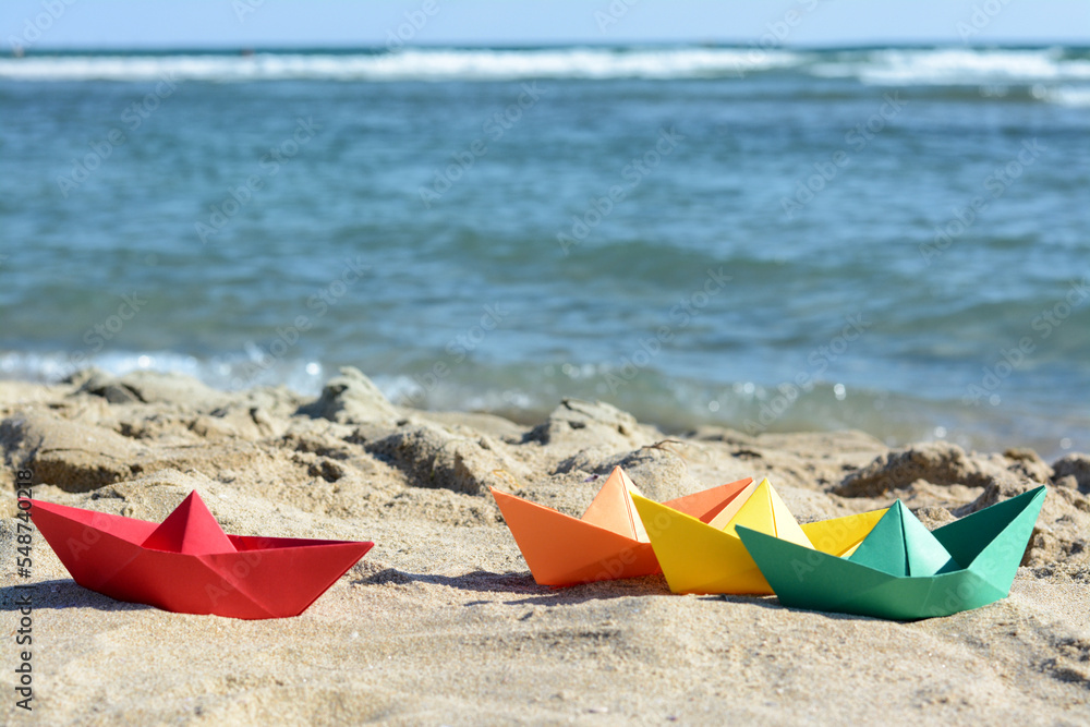 Many paper boats near sea on sunny day Many paper boats near sea on sunny day