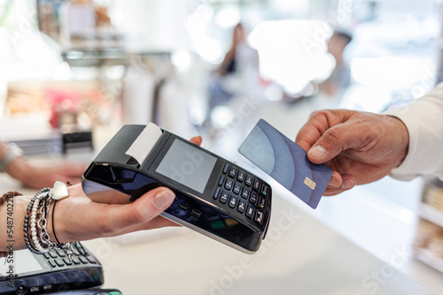 Dettaglio del pagamento con carta di credito da parte di un cliente alla cassa di un negozio.