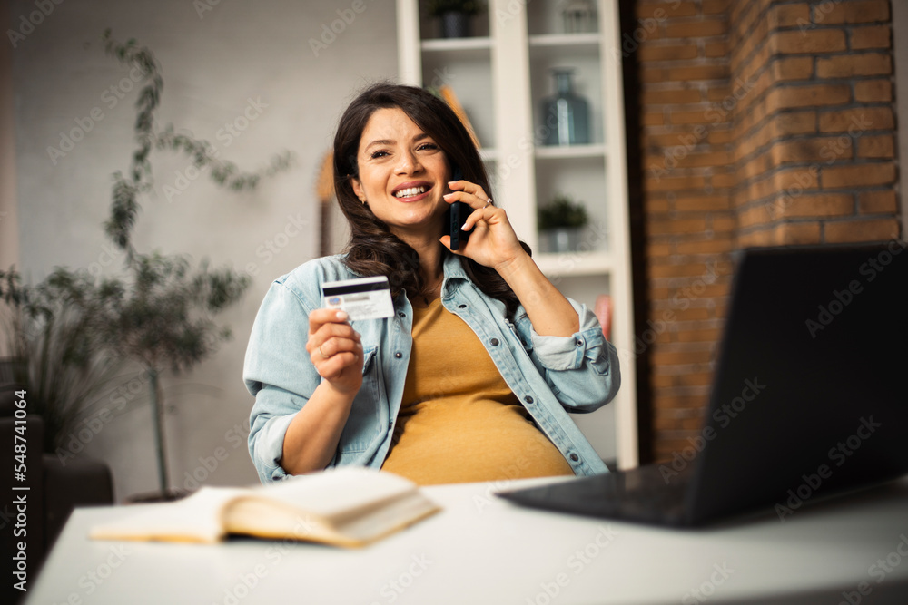 Pregnant woman shopping online at home. Happy woman with laptop and credit card. Pregnant woman shopping online at home. Happy woman with laptop and credit card.