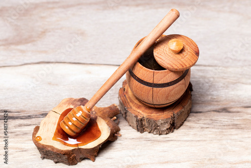 Dark honey in a wooden barrel and dipper, honey barrel on a wooden stand