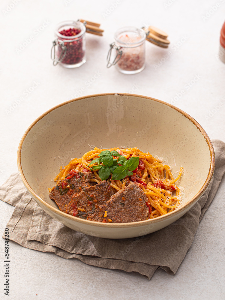 Portion of gourmet spaghetti pasta arrabbiata with roast beef Portion of gourmet spaghetti pasta arrabbiata with roast beef