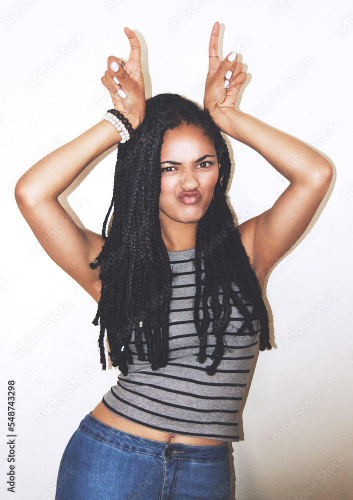 Portrait, hand gesture and horns with a black woman posing in studio on a gray background for quirky fun. Face, fashion and beauty with an attractive young female making a devil horn sign with hands Portrait, hand gesture and horns with a black woman posing in studio on a gray background for quirky fun. Face, fashion and beauty with an attractive young female making a devil horn sign with hands