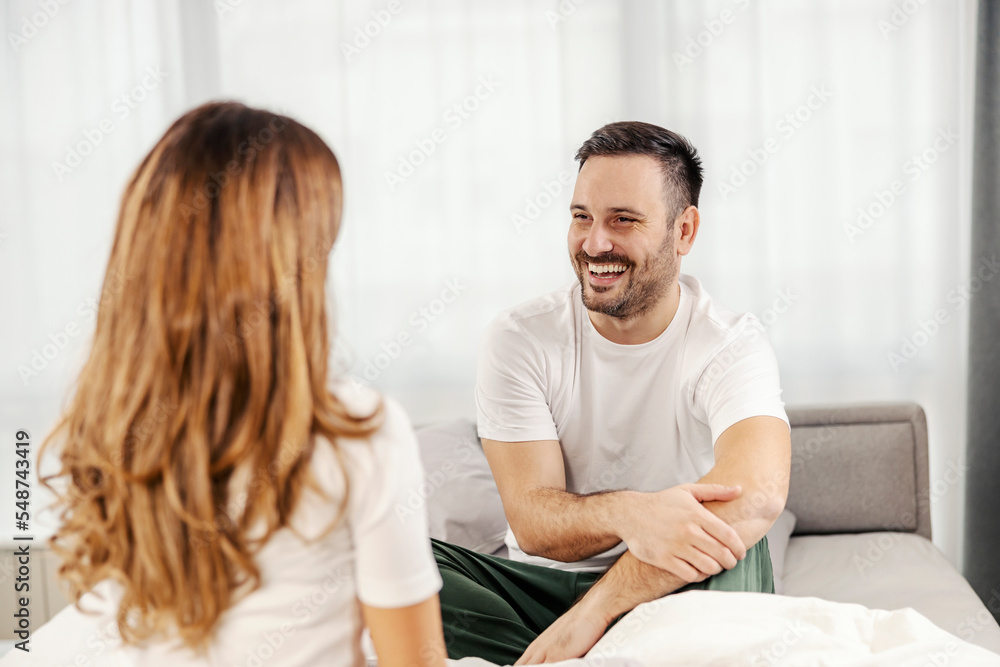 A happy morning couple is chatting and smiling at each other in their bed in the morning. A happy morning couple is chatting and smiling at each other in their bed in the morning.