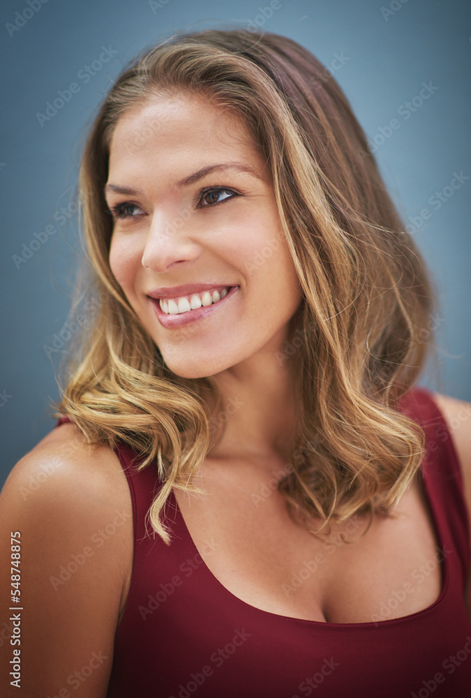 Thinking, happy and woman with a vision, smile and happiness against a blue background in studio. Idea, hair care and face of a salon model with natural beauty, young and confident on a wall Thinking, happy and woman with a vision, smile and happiness against a blue background in studio. Idea, hair care and face of a salon model with natural beauty, young and confident on a wall