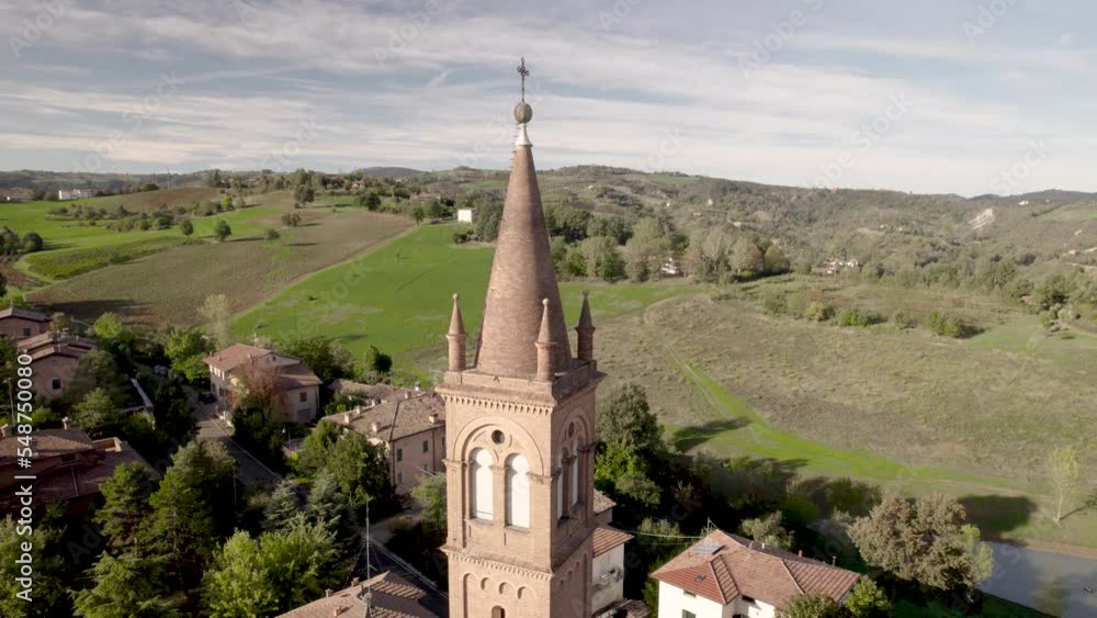 4K drone backward flight from Levizzano Rangone church in Emilia Romagna in Italy on a sunny Autumn morning
