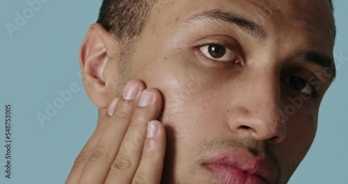 Positive man applying face cream. Closeup of male model with fresh skin applying