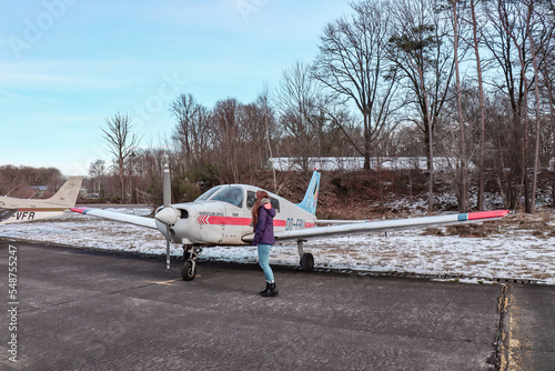 Woman standing next to a sport airplane.  photo