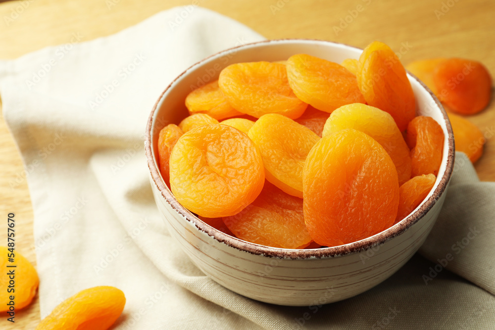 Bowl of tasty apricots on wooden table, closeup. Dried fruits Bowl of tasty apricots on wooden table, closeup. Dried fruits