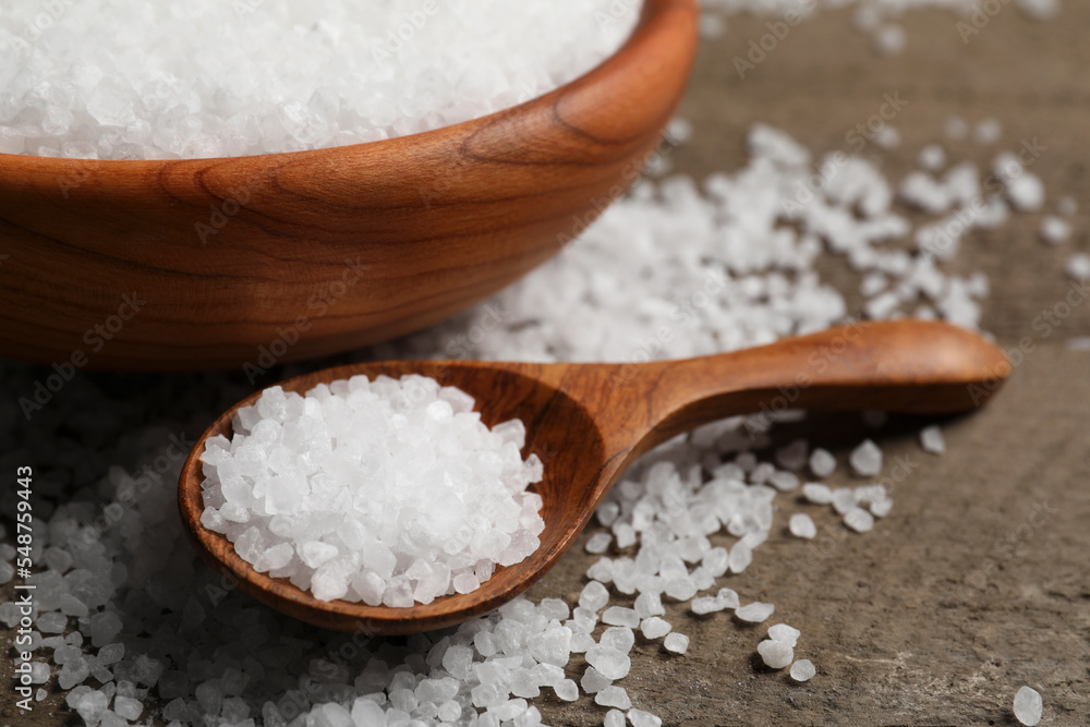 Bowl and spoon with sea salt on wooden table, closeup Bowl and spoon with sea salt on wooden table, closeup