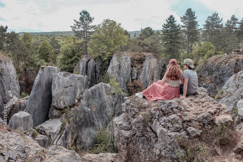 Couple sitting on rock enjoying the views of the nature of Fondry des Chiens in Vironinval Belgium. Couple sitting on rock enjoying the views of the nature of Fondry des Chiens in Vironinval Belgium.