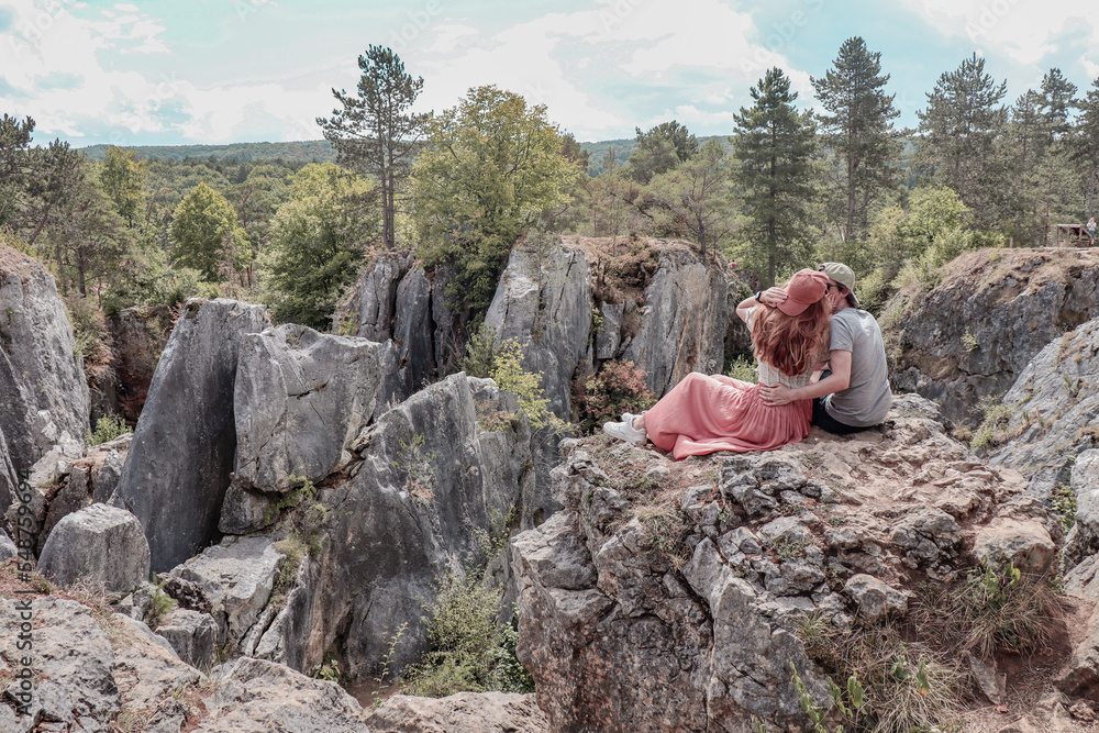 Couple sitting on rock enjoying the views of the nature of Fondry des Chiens in Vironinval Belgium.