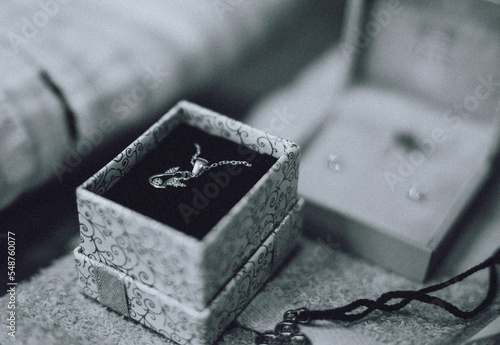 A little golden cross in a jewelry box prepared for a baby's christening baptism ceremony. Black and white photo. High quality photo