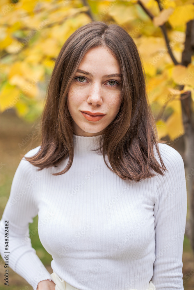 Young beautiful brown-haired girl in autumn park Young beautiful brown-haired girl in autumn park