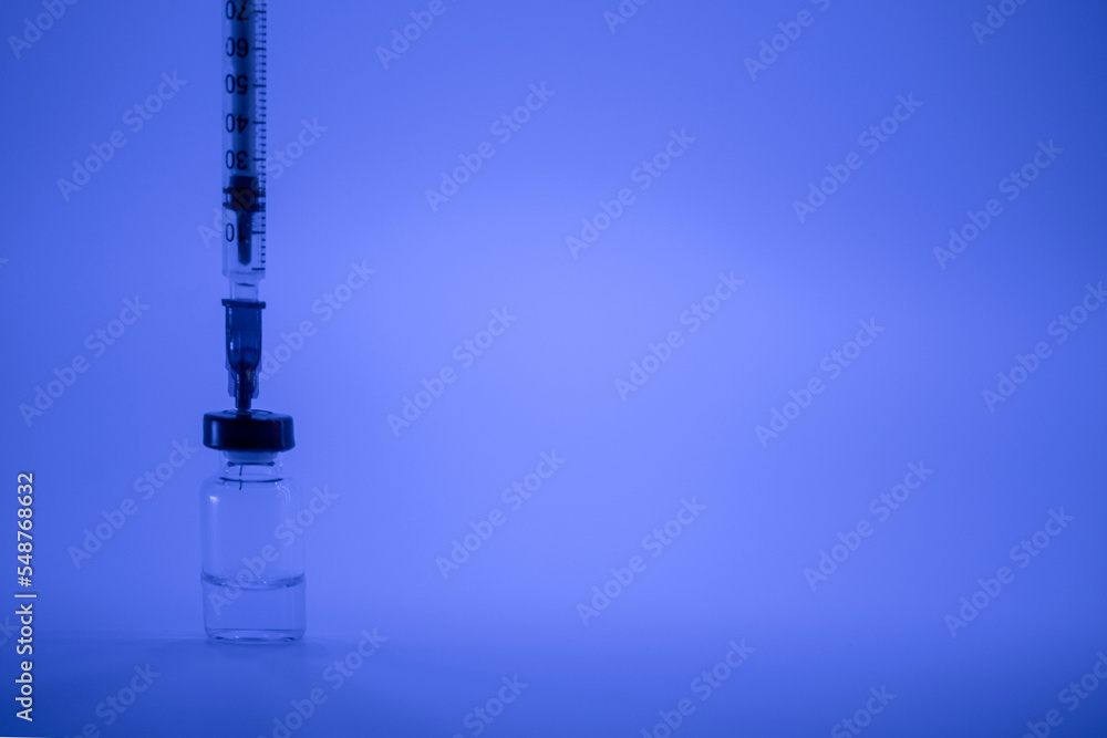 Vaccine vial, syringe with flu shot needle, vaccination medical concept, subcutaneous injection on blue background. Copy space. Test immunization and vaccination laboratory. Healthcare and medicine Vaccine vial, syringe with flu shot needle, vaccination medical concept, subcutaneous injection on blue background. Copy space. Test immunization and vaccination laboratory. Healthcare and medicine