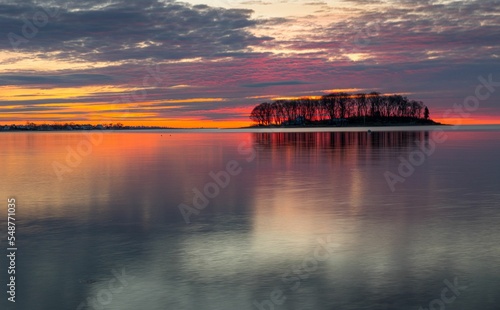 Picturesque view of the shoreline in Norwalk, Connecticut with colorful sky reflecting in the ocean photo
