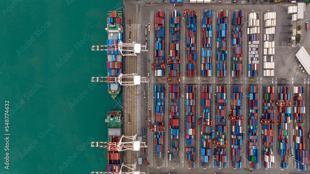 commercial port loading and unloading cargo from container ship import and export by crane for distributing goods by trailers transported to customers and dealers, aerial view commercial port loading and unloading cargo from container ship import and export by crane for distributing goods by trailers transported to customers and dealers, aerial view