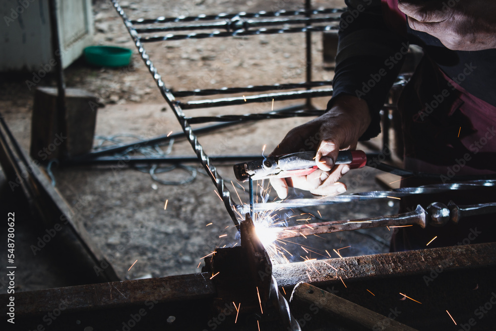 a man welds a metal with a welding machine, profession of welder, weld metal, man works with metal a man welds a metal with a welding machine, profession of welder, weld metal, man works with metal