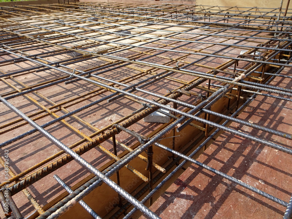 MELAKA, MALAYSIA -JULY 2, 2022: Steel reinforcement bars are arranged according to the structural engineer's design. The steels are tied together using a small steel wire. MELAKA, MALAYSIA -JULY 2, 2022: Steel reinforcement bars are arranged according to the structural engineer's design. The steels are tied together using a small steel wire.