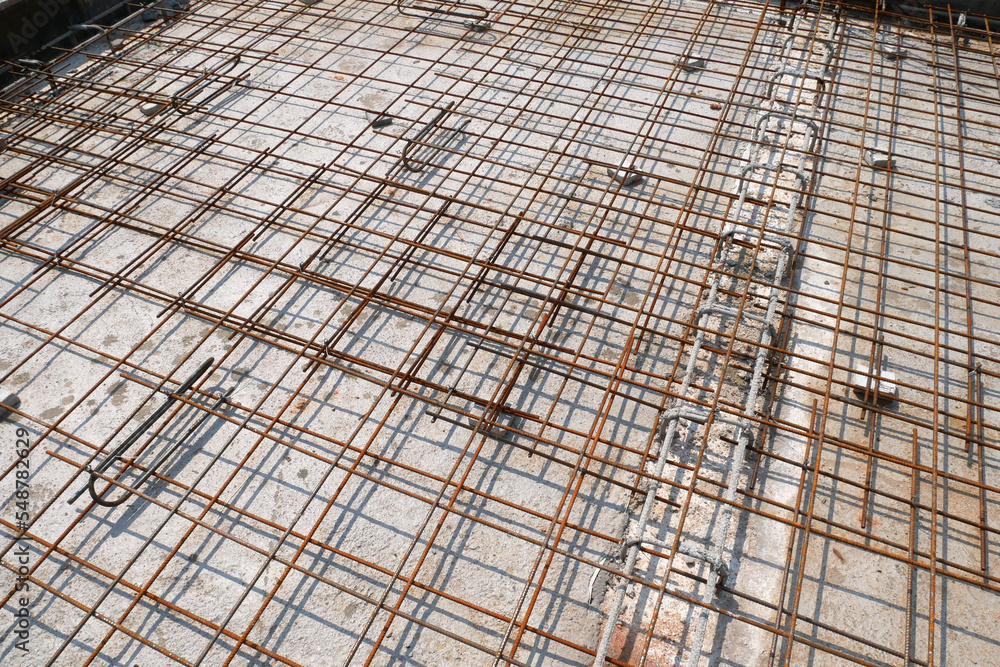 MELAKA, MALAYSIA -JULY 2, 2022: Steel reinforcement bars are arranged according to the structural engineer's design. The steels are tied together using a small steel wire.