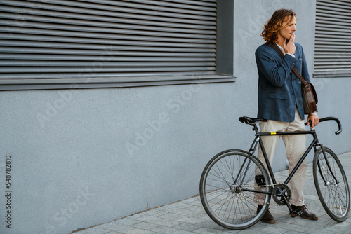 Young man smoking cigarette while standing with bicycle