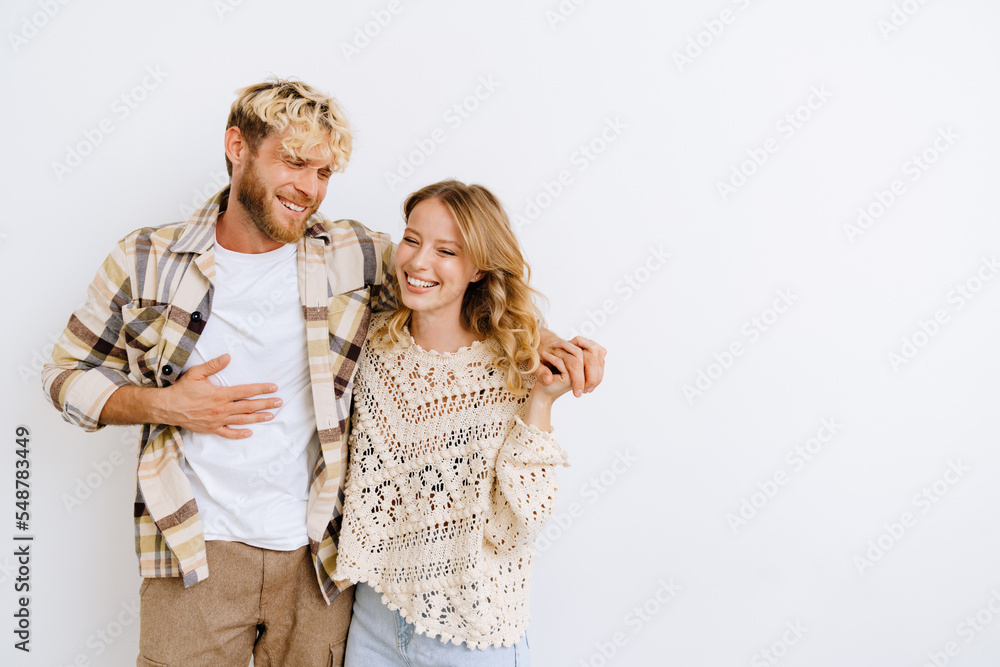 Man and woman laughing and hugging isolated over white background