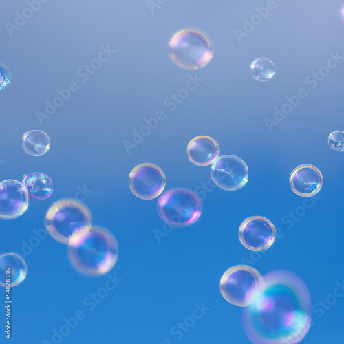 Group of colorful soap bubbles in the air in front of blue sky