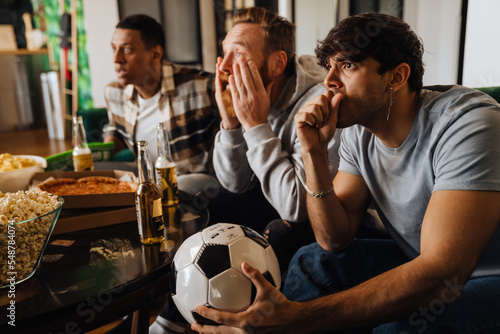 Εκτύπωση καμβά Upset male friends watching sport game and drinking beer at hone