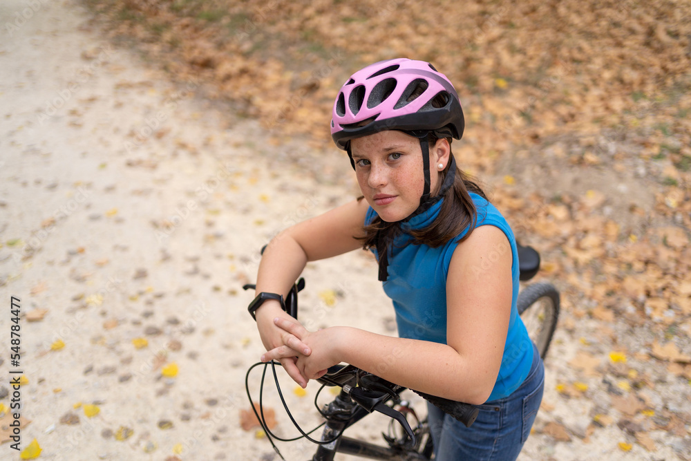 Happy girl leaning on bike handlebar Happy girl leaning on bike handlebar