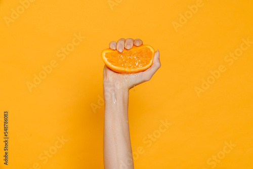 Φωτογραφία Female hand squeezing orange isolated