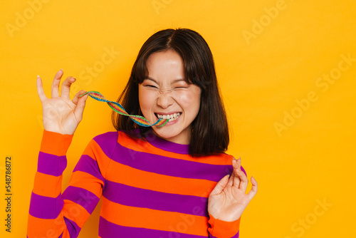 Fototapeta Naklejka Na Ścianę i Meble -  Asian brunette woman smiling and holding ice cream