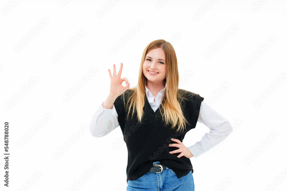 a blonde in a black vest shows an ok sign from the fingers on a white background a blonde in a black vest shows an ok sign from the fingers on a white background