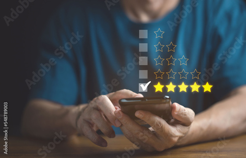 Close up Man hand using smart phone and give five star symbol to increase rating of product and service concept, Customer service and business satisfaction survey,selective focus.