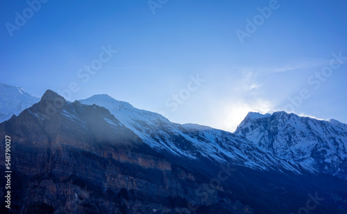 Sunrise over the mountains of Anapurna in Nepal. Snowy mountain peaks and blue sky as copy space.