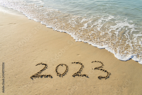 2023 handwritten in sand on a beautiful beach